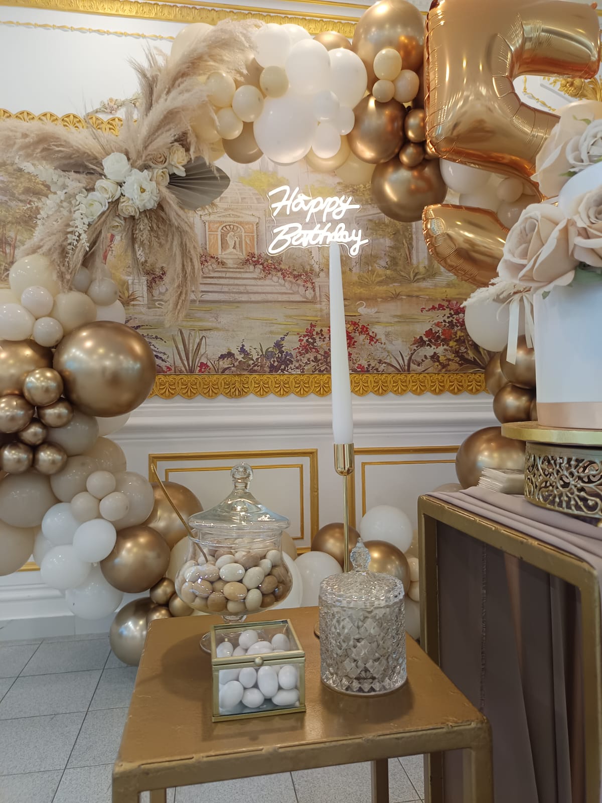 Allestimento 50 anni: arco di palloncini oro e nude con pampas